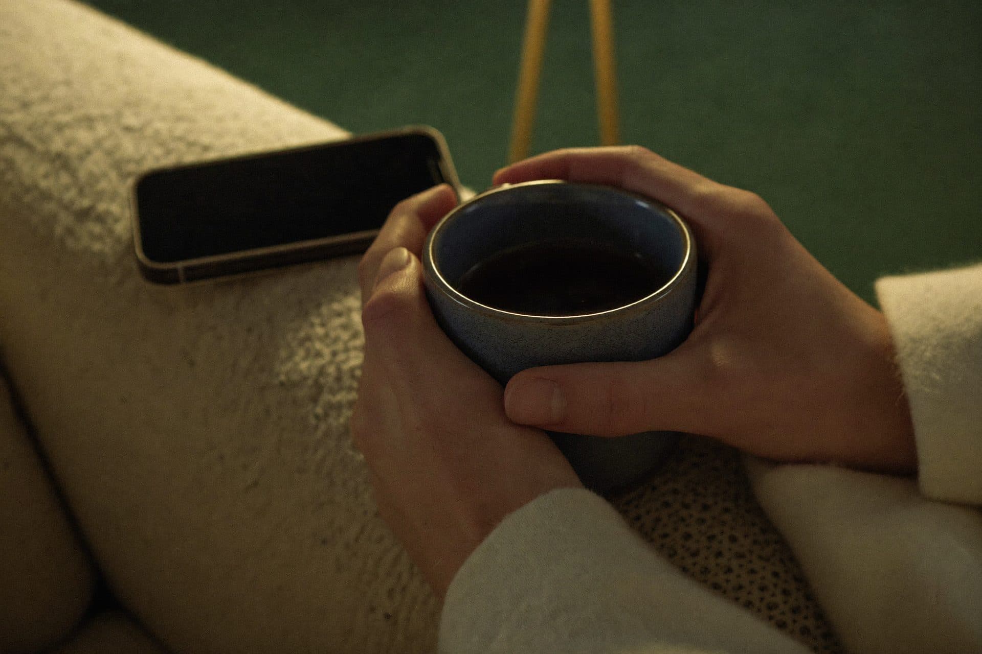Hands cradling a warm mug on a quiet evening