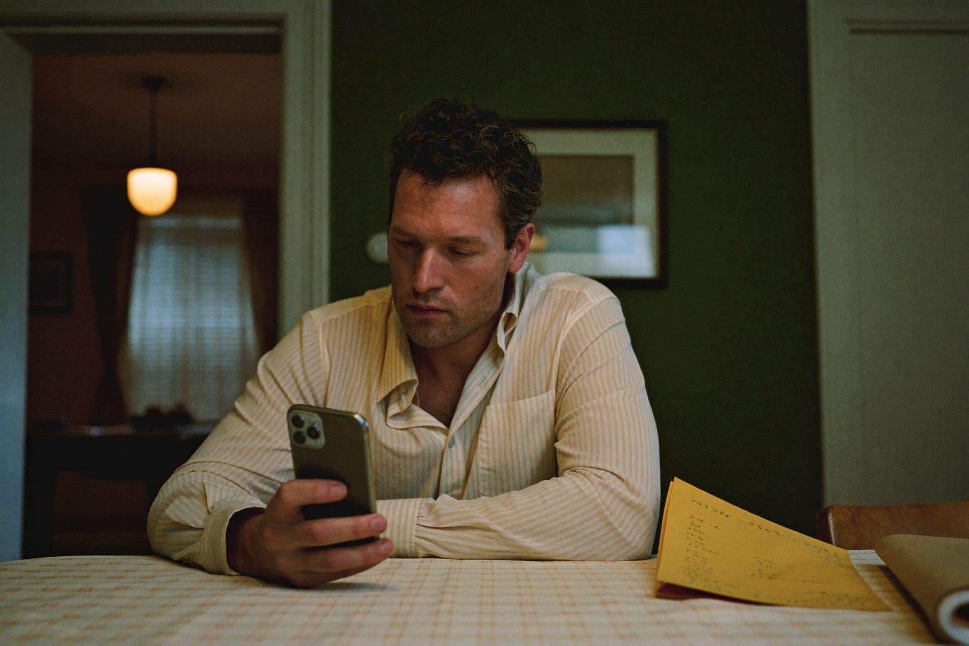 A man at a dining table in the evening, thoughtful, easing